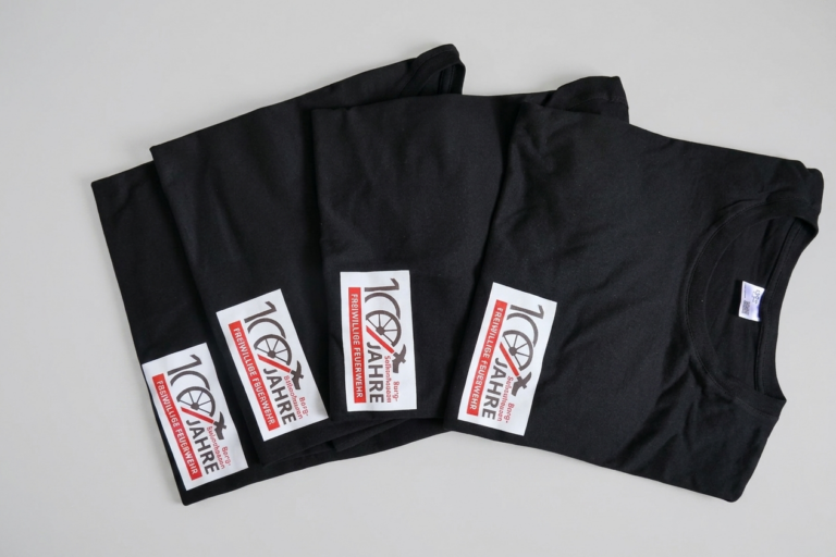 T-Shirts mit einem Jubiläumslogo im DTF-Druckverfahren versehen